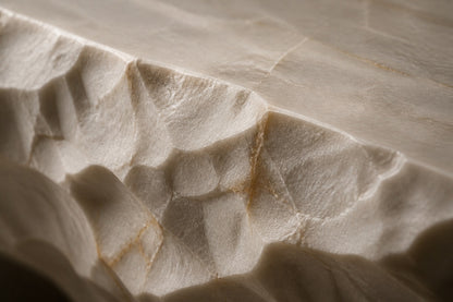 White quartzite fire table Himara 220, bright white with warm inclusions, on a pale stone floor.