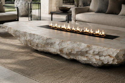 White quartzite fire table Himara 220, bright white with warm inclusions, on a pale stone floor.