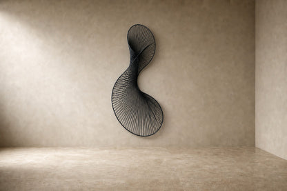 Graphite steel wall sculpture Iltifat, a single sheet folded through itself in one continuous turn, on a plaster wall.