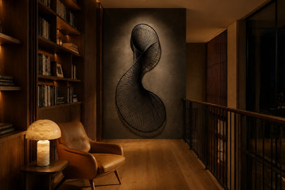 Graphite steel wall sculpture Iltifat, a single sheet folded through itself in one continuous turn, on a plaster wall.