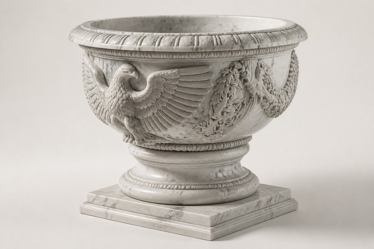 Imperial Eagle Marble Urn Planter — 110 cm white Carrara marble urn planter with a heavy carved rim and a carved eagle, three-quarter studio view showing its profile