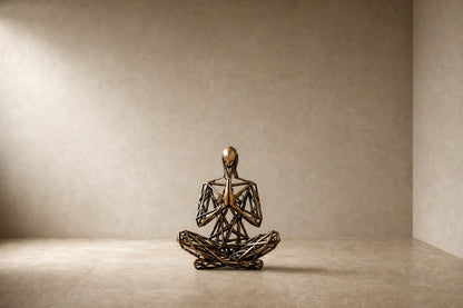 Bronze strut-cage seated figure sculpture Intreccio in lotus with hands together, on a quilted travertine block.