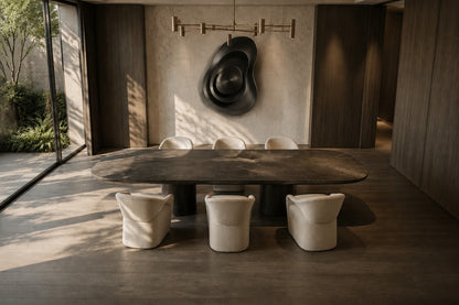 Iron grey bronze wall sculpture Roca, a cast boulder form mounted proud of a spun disc, on a plaster wall.