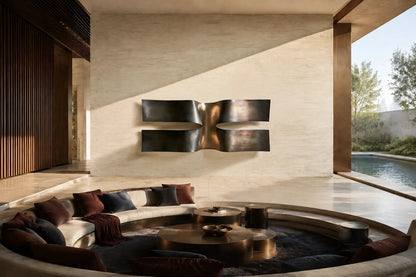 Dark bronze bronze wall sculpture Ponte, two cantilevered spans meeting at a knotted centre, on a plaster wall.