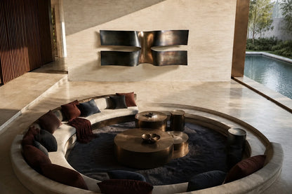 Dark bronze bronze wall sculpture Ponte, two cantilevered spans meeting at a knotted centre, on a plaster wall.