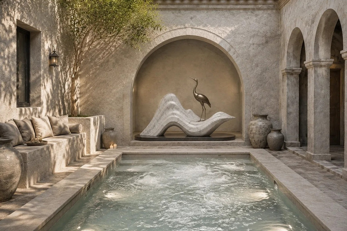 White marble wave sculpture Juncal in four crests with a slender bronze figure standing at the high point, on a dark granite oval base.