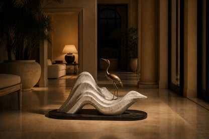 White marble wave sculpture Juncal in four crests with a slender bronze figure standing at the high point, on a dark granite oval base.