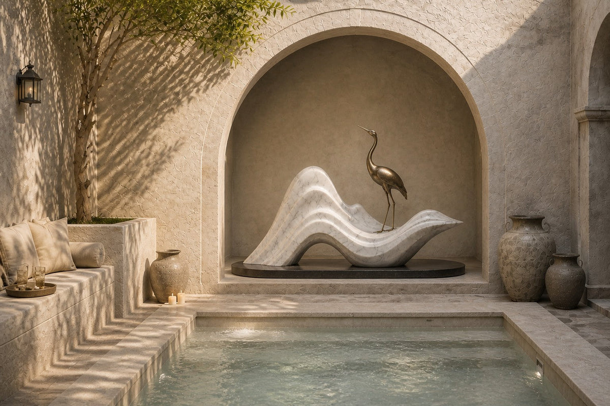 White marble wave sculpture Juncal in four crests with a slender bronze figure standing at the high point, on a dark granite oval base.
