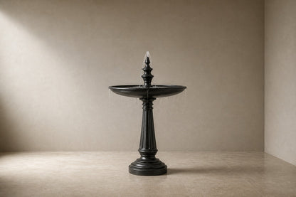 Stone pedestal fountain Kasumia Ø65, matte charcoal, on a pale stone floor.