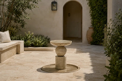 Stone pedestal fountain Kathib Ø65, pale warm stone, on a pale stone floor.