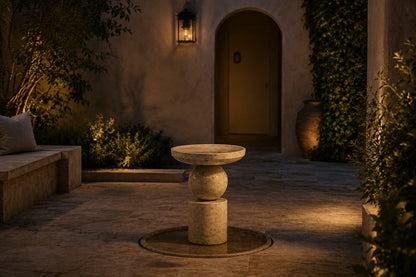 Stone pedestal fountain Kathib Ø65, pale warm stone, on a pale stone floor.