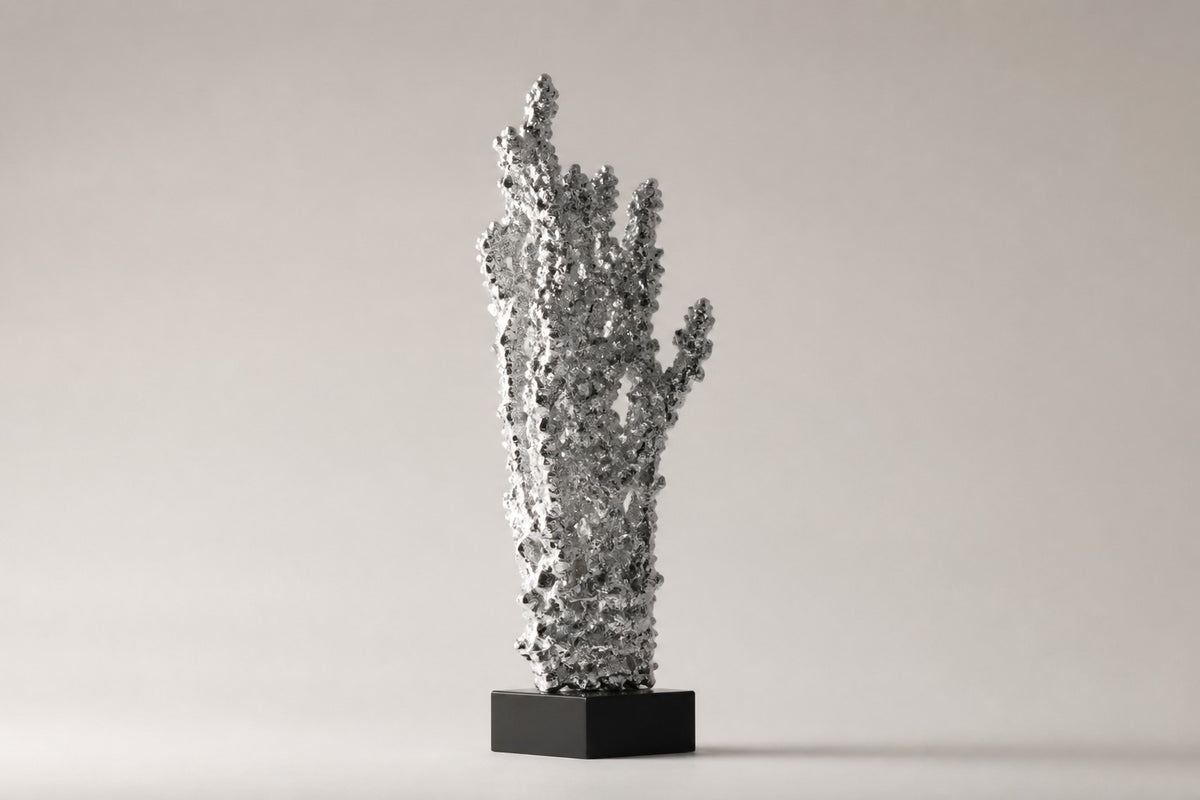 Kessho — silver crystal-cluster sculpture growing upward like frosted coral, studio side angle showing its depth