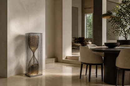 Woven bronze wire sculpture Kochab, an hourglass form packed with loose wire, suspended inside a tall wire case.
