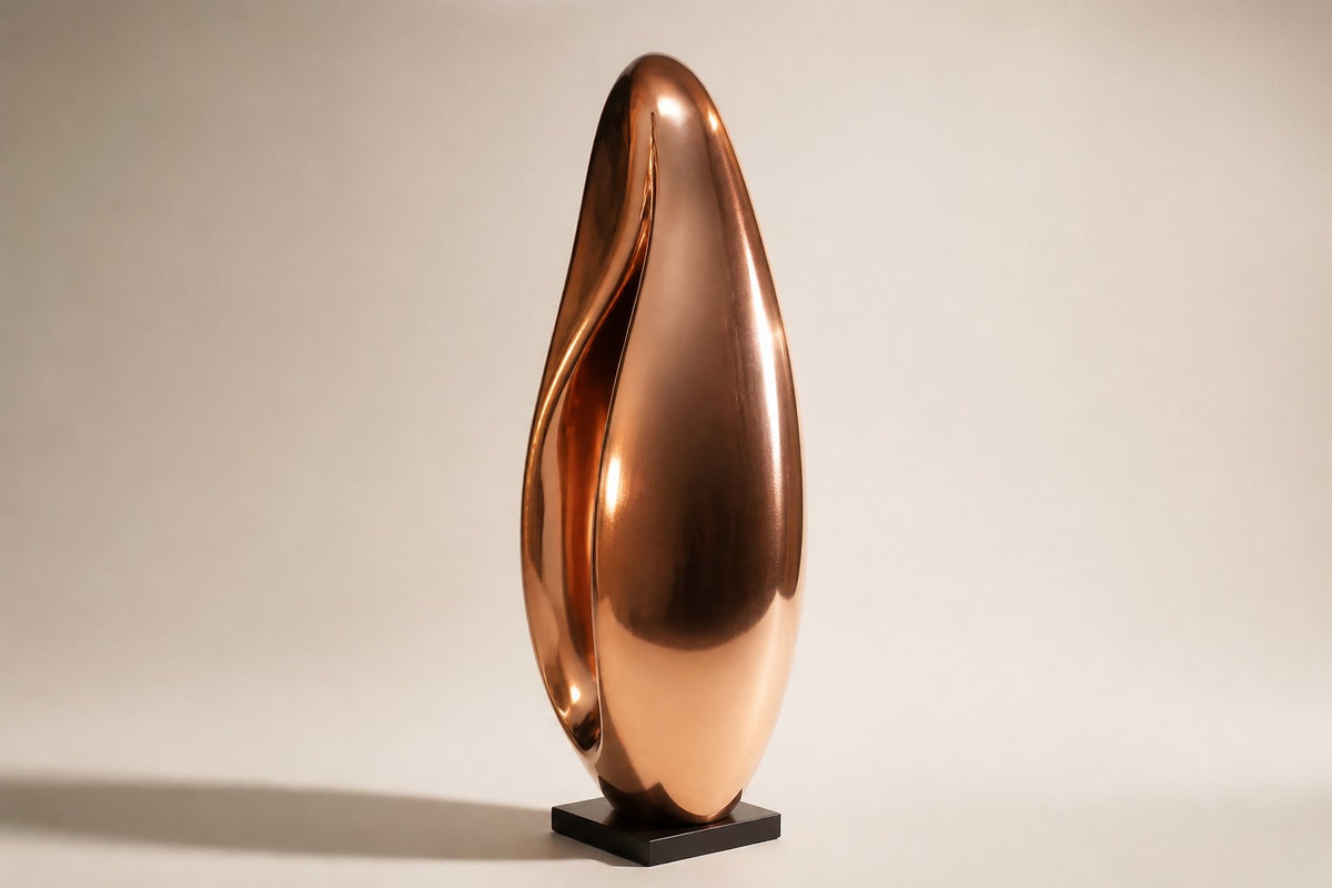 Lahab — 60 cm mirror-polished copper ovoid sculpture with a deep flame-like fold, three-quarter studio view showing its profile