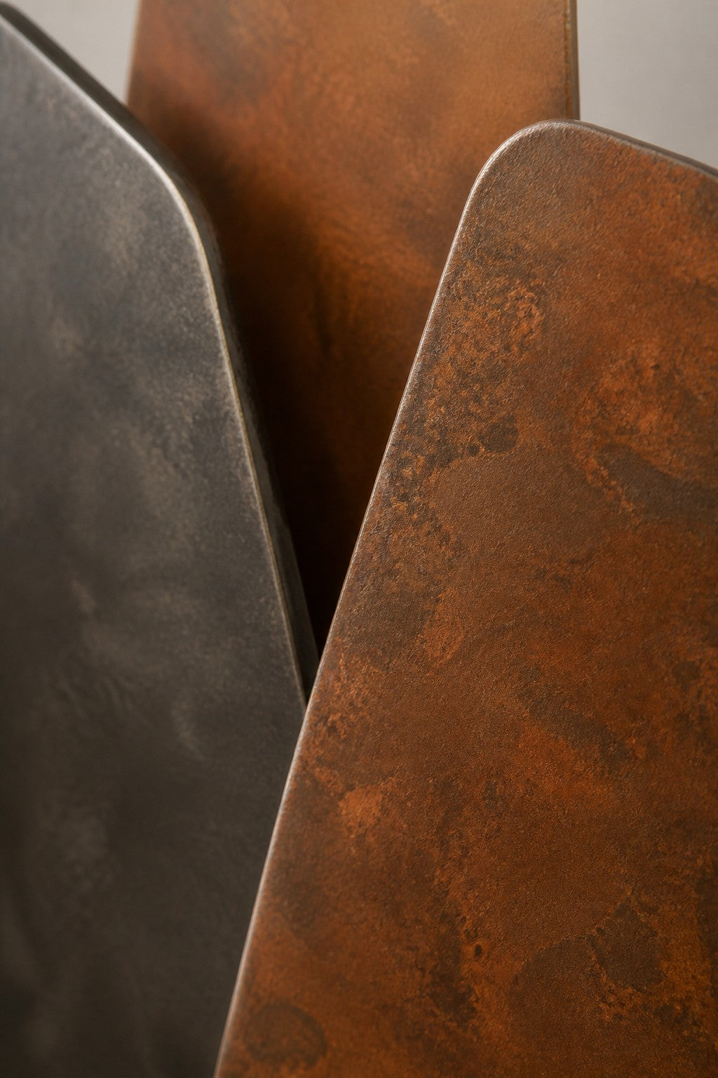 Lama — 85 × 140 cm wall sculpture of stacked blades in rust-orange and dark bronze, close studio detail of the surface and material