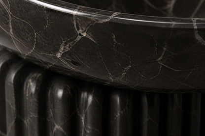 Dark marble pedestal fountain Layla Ø65, deep black with white veining, on a pale stone floor.