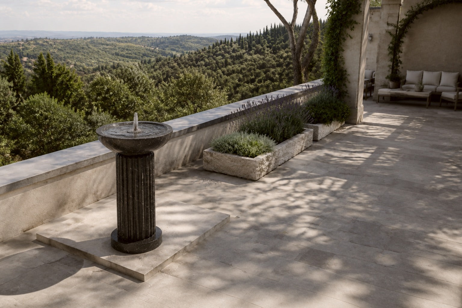 Dark marble pedestal fountain Layla Ø65, deep black with white veining, on a pale stone floor.