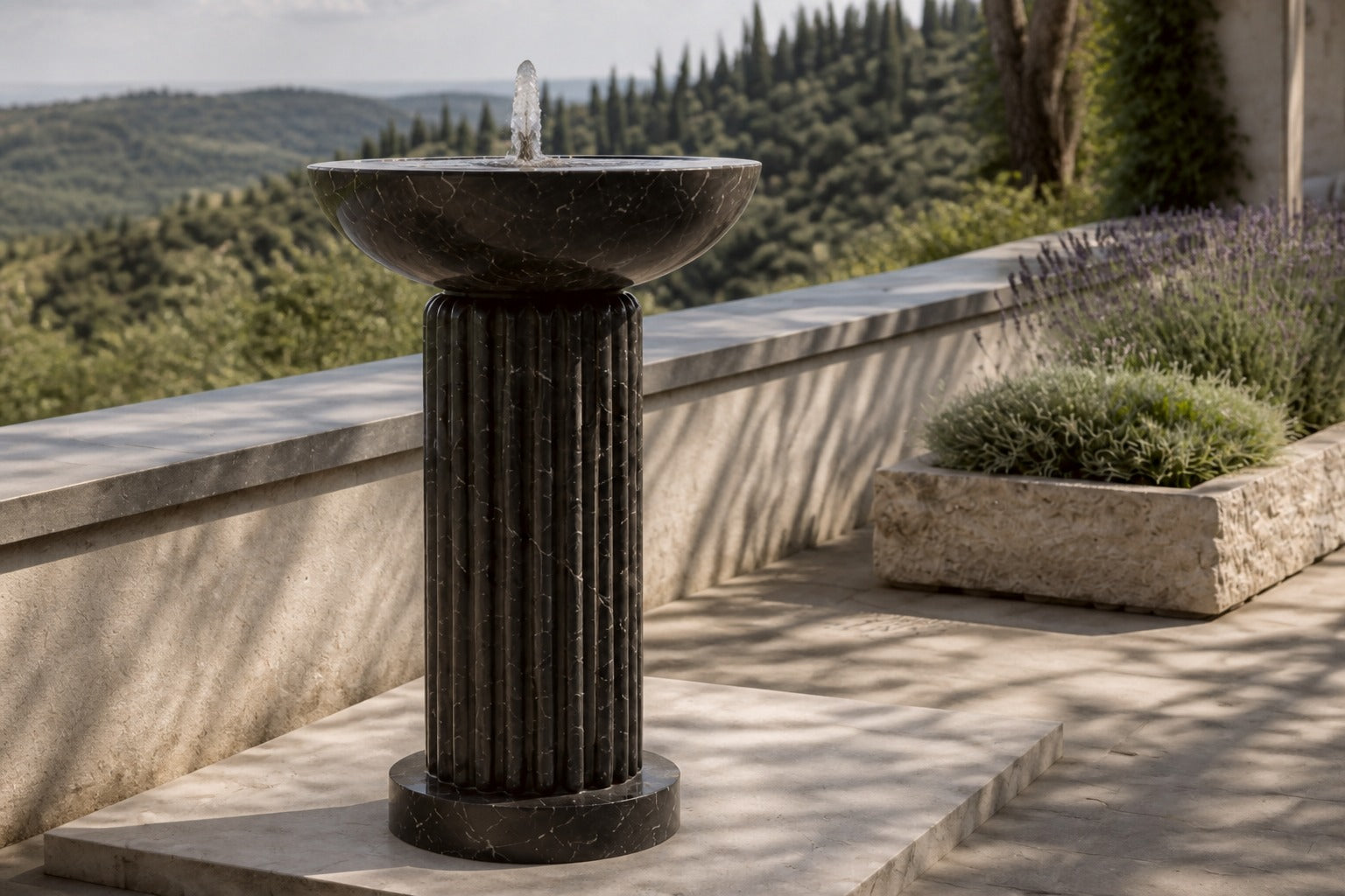 Dark marble pedestal fountain Layla Ø65, deep black with white veining, on a pale stone floor.