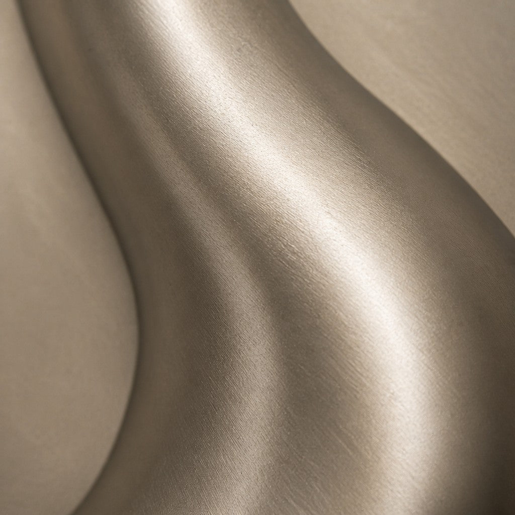Lazo — 110 × 110 cm framed relief of a polished brass loop on a pale ground, close studio detail of the surface and material