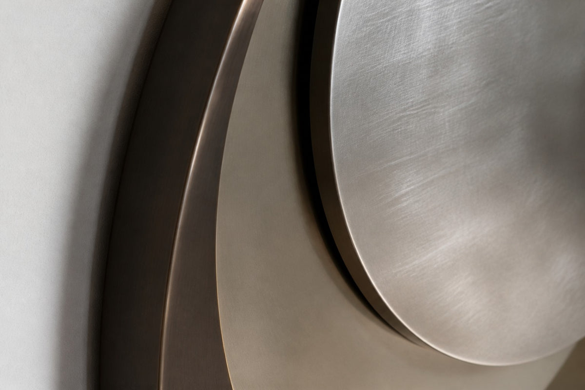 Lente — Ø 200 cm bronze ring mirror with an off-centre brushed steel lens, close detail of the surface and edge