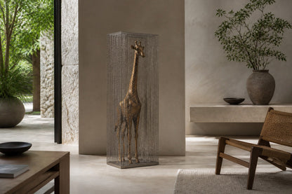 Tall bronze figure sculpture Llanura with a crackled patina, standing inside a fine drawn-wire case on a bronze plinth.