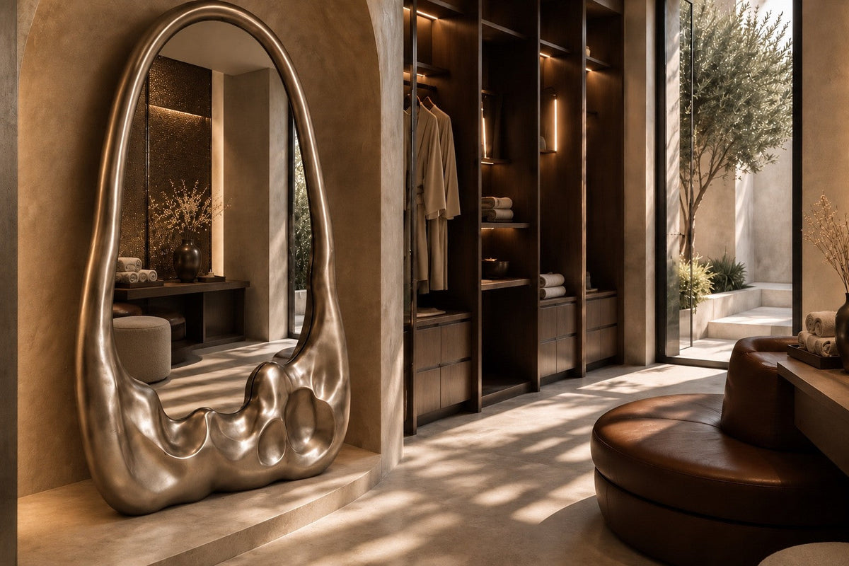 Lucidez — 110 × 200 cm tall standing mirror with a brushed stainless steel frame melting at the base, close view in the room