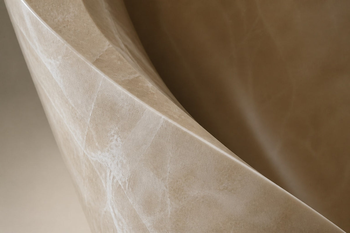 LUMEN VEIL — pale cream marble abstract sculpture on a black cube plinth, close detail of the marble surface and edge