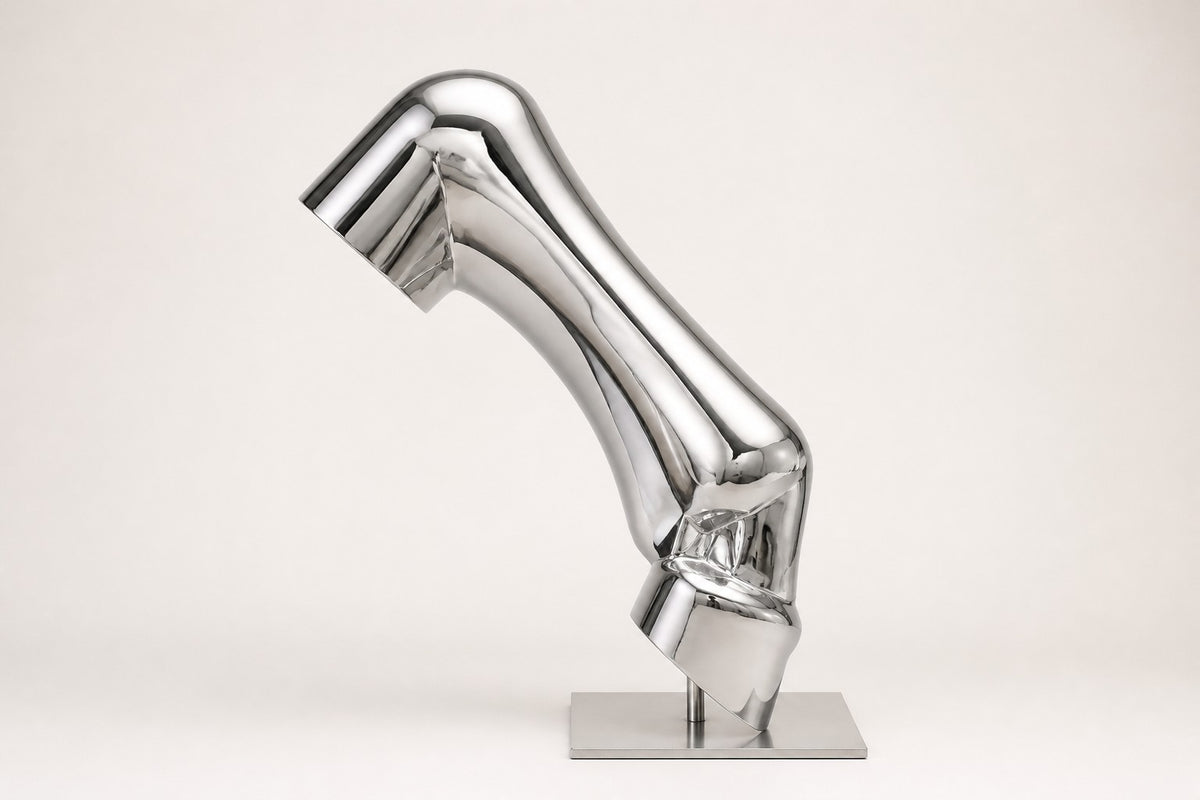 Magari — 140 cm mirror-polished steel sculpture of a bent, creased tube rising from a slim base, studio view of the whole piece