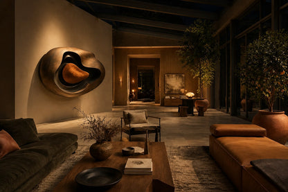 Nested ovoid bronze walls around a warm tan polished core, standing on a stone floor.