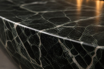 Dark green-black marble fire bowl Mayura Ø180, dark green-black with white veining, on a pale stone floor.