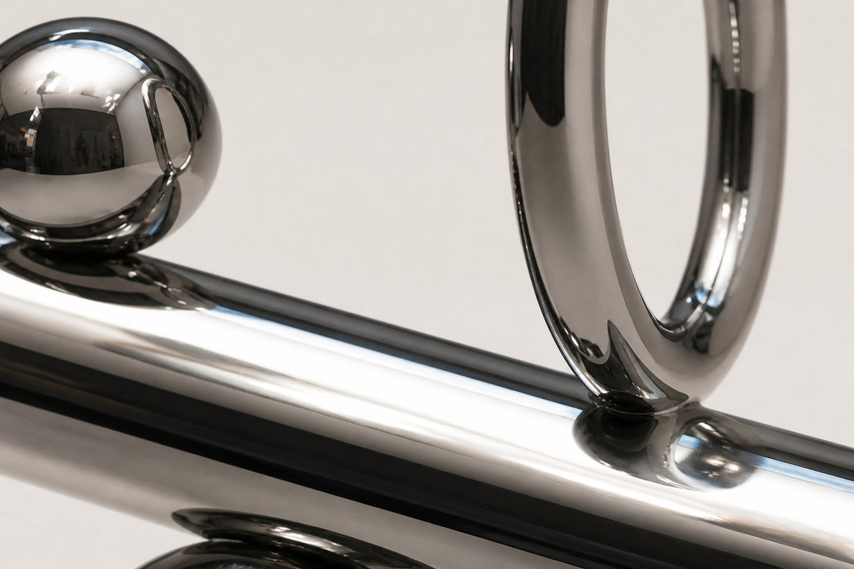 Mintaka — mirror chrome balancing ring and cylinder sculpture, close detail of the surface and edge