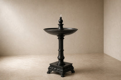 Stone pedestal fountain Mirala Ø65, dark charcoal, on a pale stone floor.