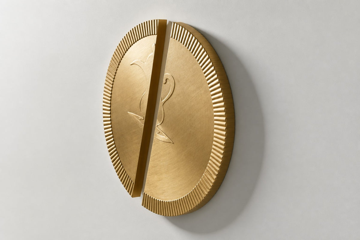 Mitad — Ø 200 cm brushed brass circular wall relief split into two offset fluted halves, three-quarter studio view showing its profile