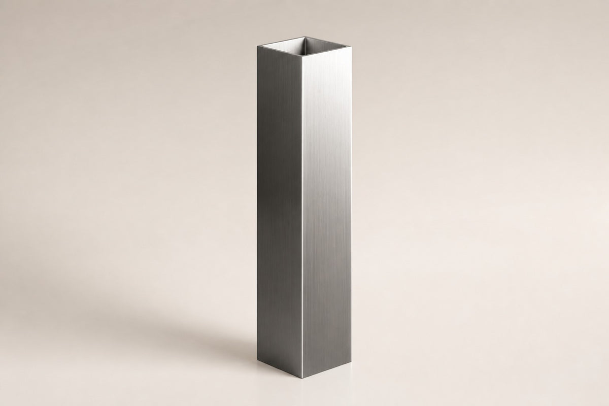 Monolith Brushed Stainless Steel Column Planter — 140 cm slim brushed stainless steel column planter with a trailing plant, three-quarter studio view showing its profile