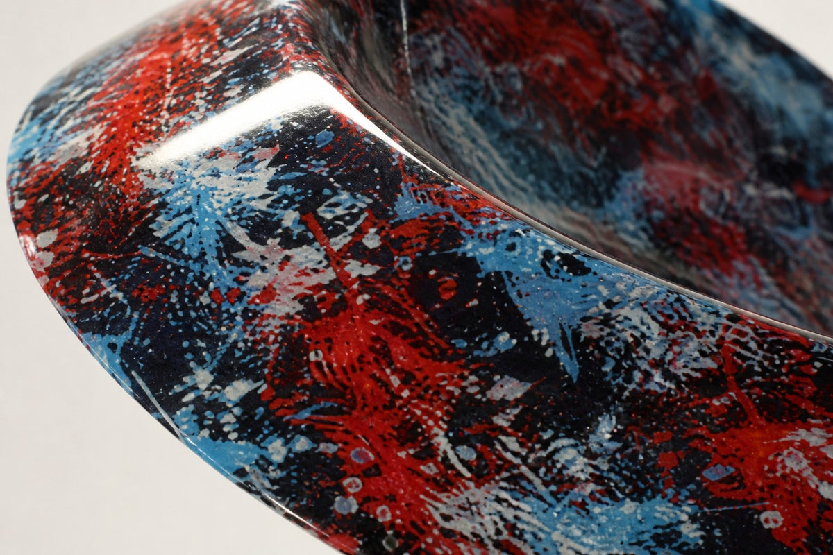 Muyu — red and blue marbled swirl sculpture on a black base, close detail of the surface and edge