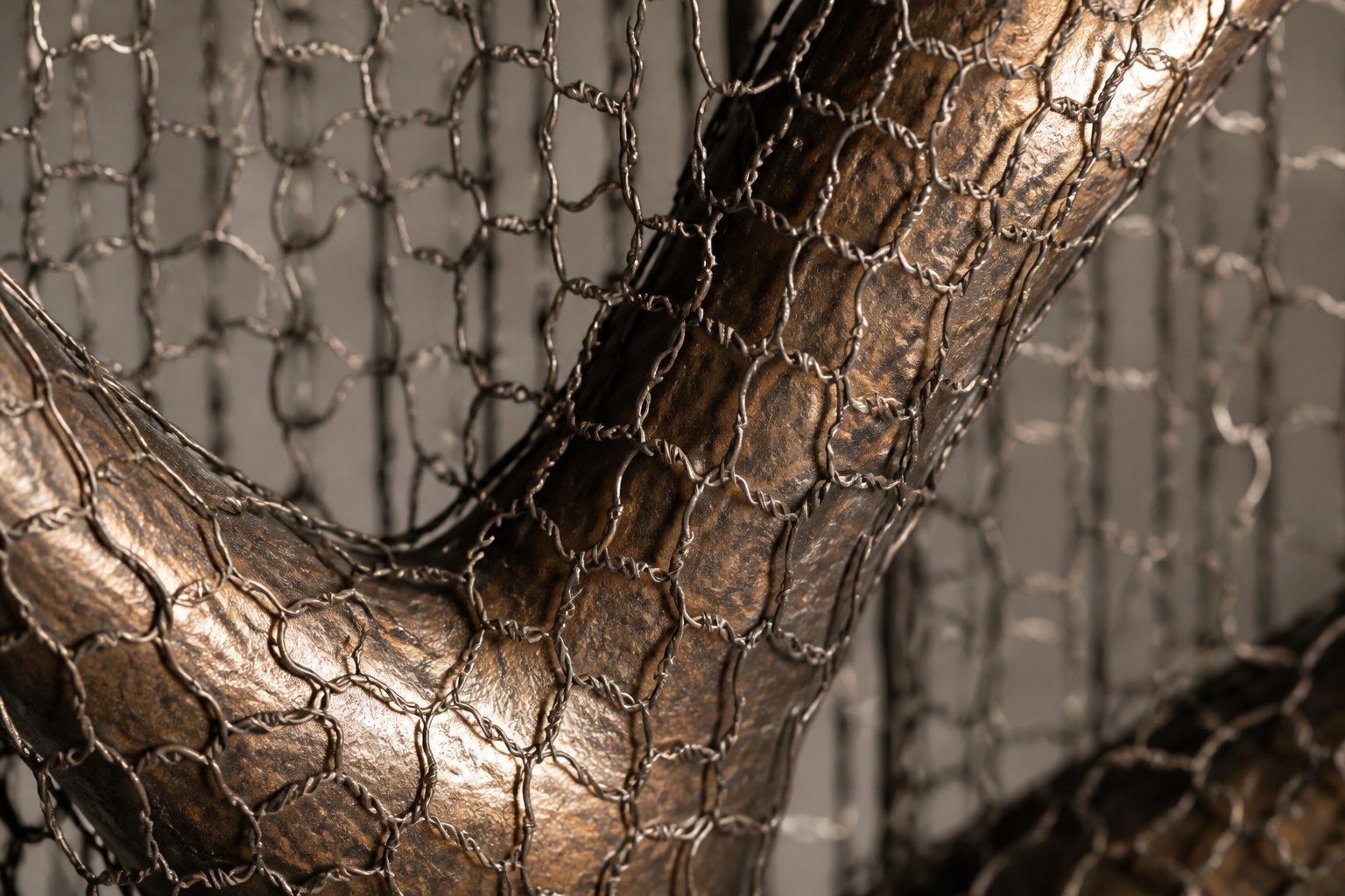 Bronze branching sculpture Nafud with a pitted weathered patina, held upright inside a tall fine drawn-wire case.