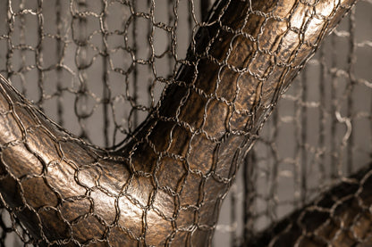 Bronze branching sculpture Nafud with a pitted weathered patina, held upright inside a tall fine drawn-wire case.