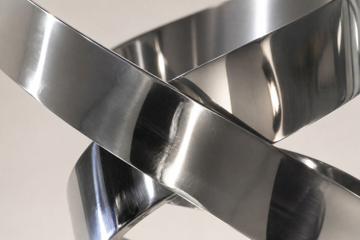 Nashira — 200 cm mirror-polished steel ribbon loops rising into an open ring, close studio detail of the surface and material