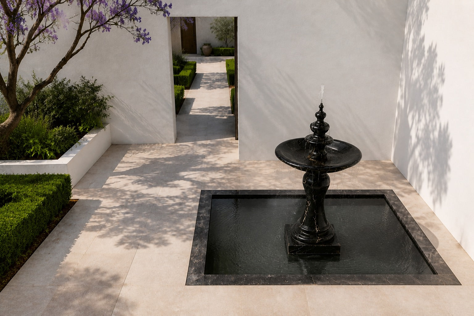Stone pedestal fountain Nasima Ø65, black with gold and amber veining, on a pale stone floor.