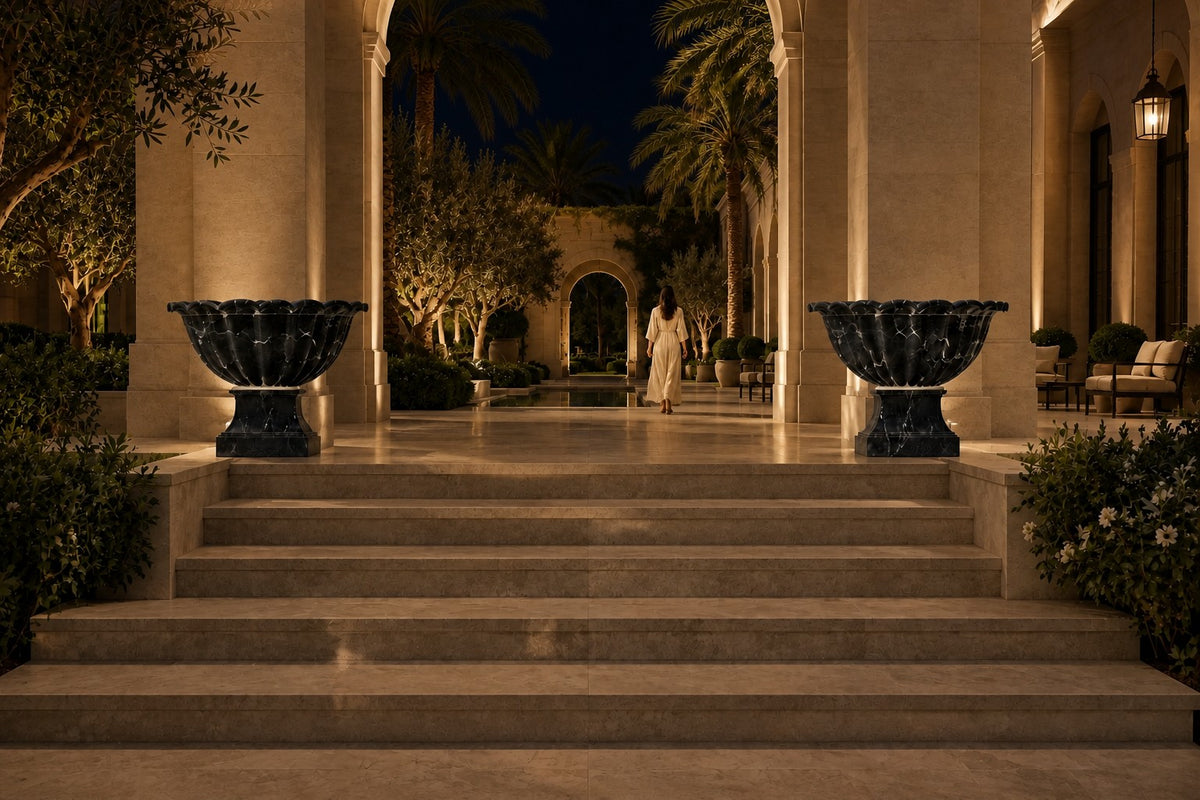 Nero Fluted Marble Urn Planter — 85 cm Nero Marquina black marble urn planter with a fluted scalloped bowl, the same room at night, lamps on