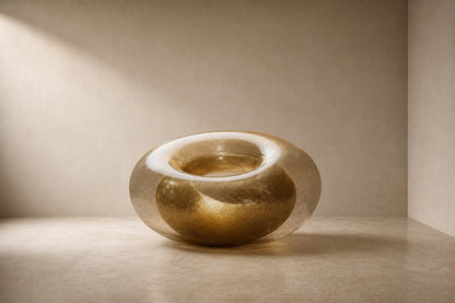 Woven brass wire torus sculpture Nunki Ø120, reading as solid gold where the mesh doubles and open gauze at the edges.