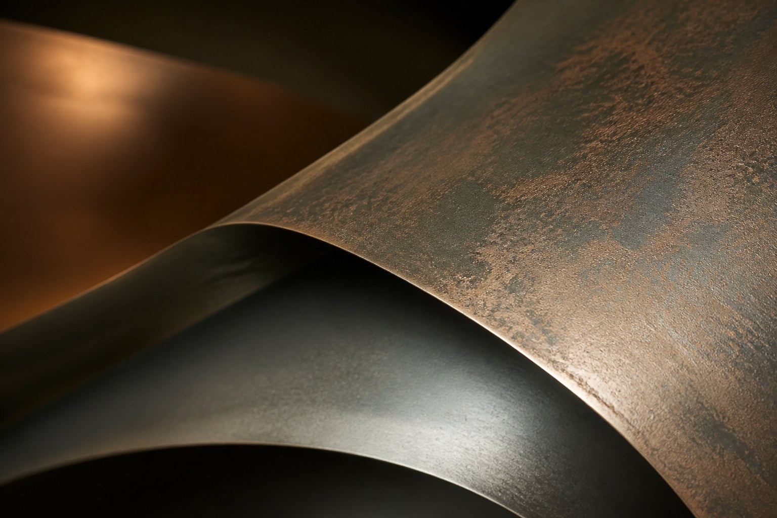 Nested ovoid bronze rings in rust and blue-grey around a polished copper core, on a stone floor.
