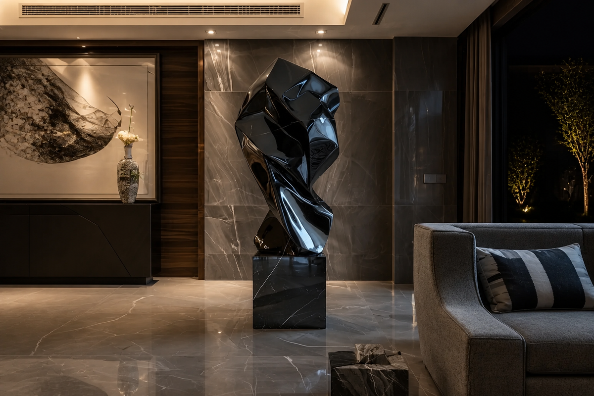 OBSIDIAN FOLD stainless steel sculpture, in a room setting under evening light