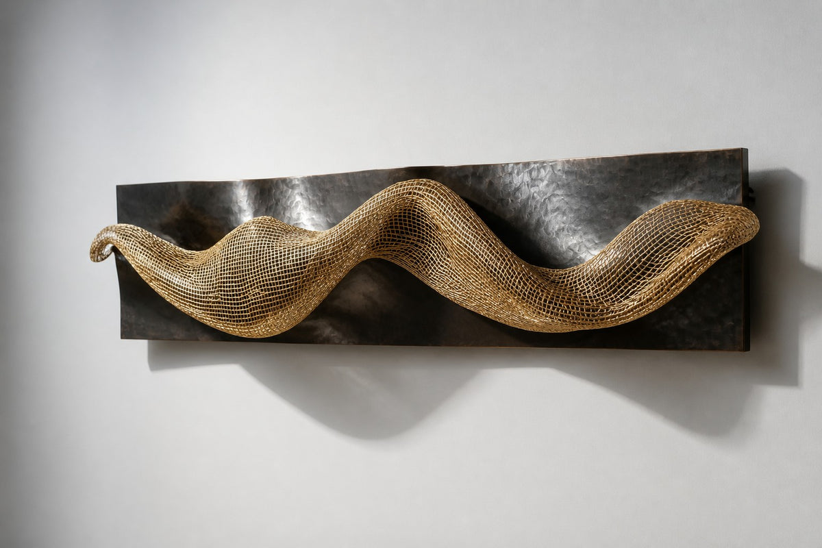 Oleaje — dark bronze wave plate crossed by a band of brass mesh, studio side angle showing its depth