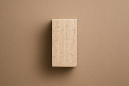 Tall cream travertine pedestal with a mouth carved in relief on one face.