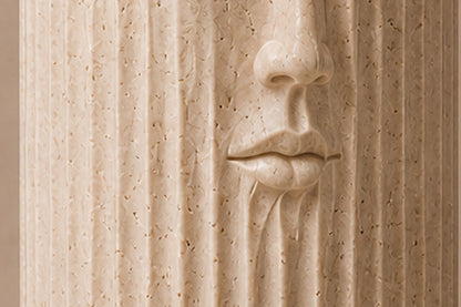 Fluted cream travertine drum on a round moulded foot, with a face carved through the flutes.