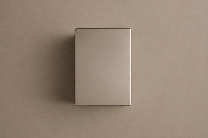 Tall mirror-polished stainless steel pedestal with a nose and mouth formed seamlessly out of one face.