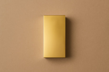 Tall gold PVD pedestal with a closed eye, nose and mouth formed seamlessly out of one face.