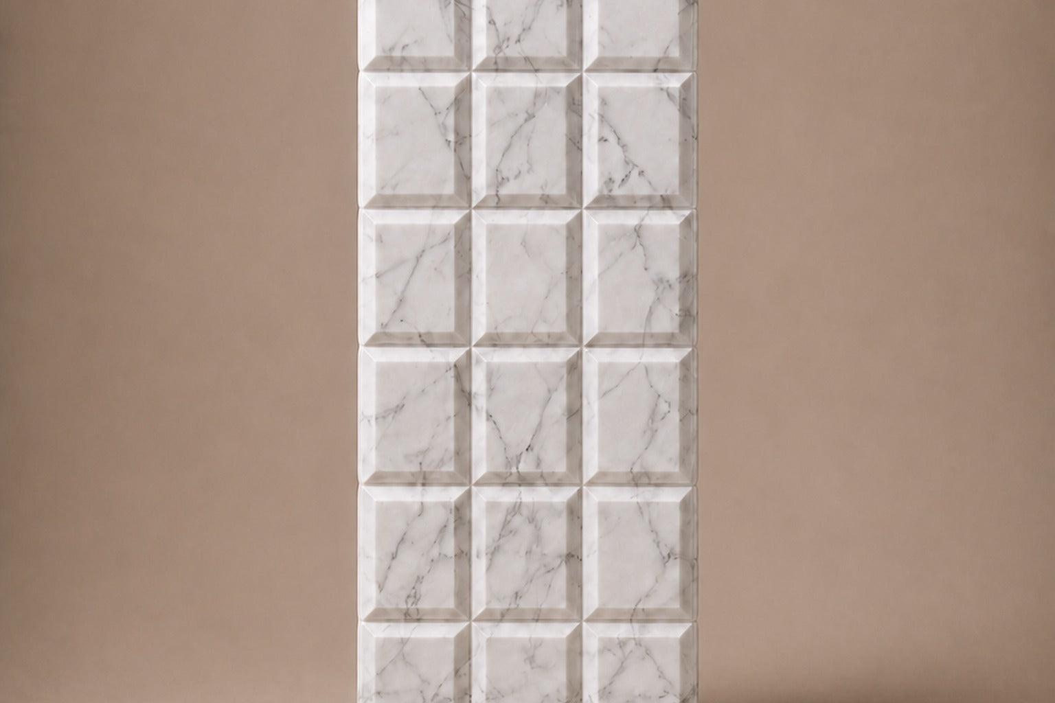 Tall white Carrara marble column carved into a grid of raised cushioned panels.