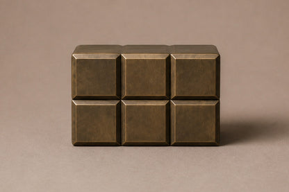 Tall antique bronze column built as a grid of raised cushioned panels.